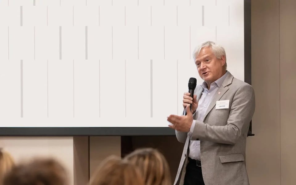 Professor Mats Karlsson, Scientific Advisor at Pharmetheus, speaking into a microphone during a presentation in front of an audience.
